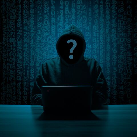 Silhouette eines Kapuzenpullover tragenden Hackers am Laptop vor einer Zahlenwand